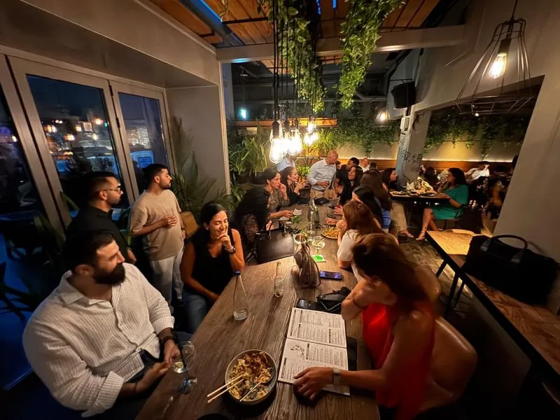 Members talking around a long table in the evening