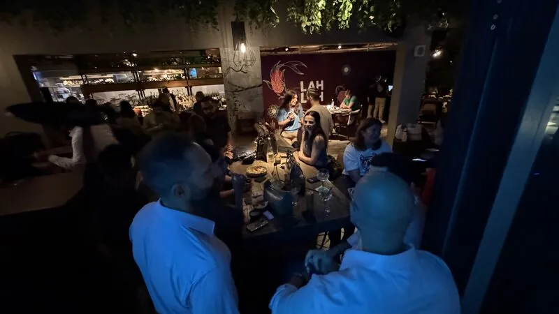 A group standing and talking beside the bar